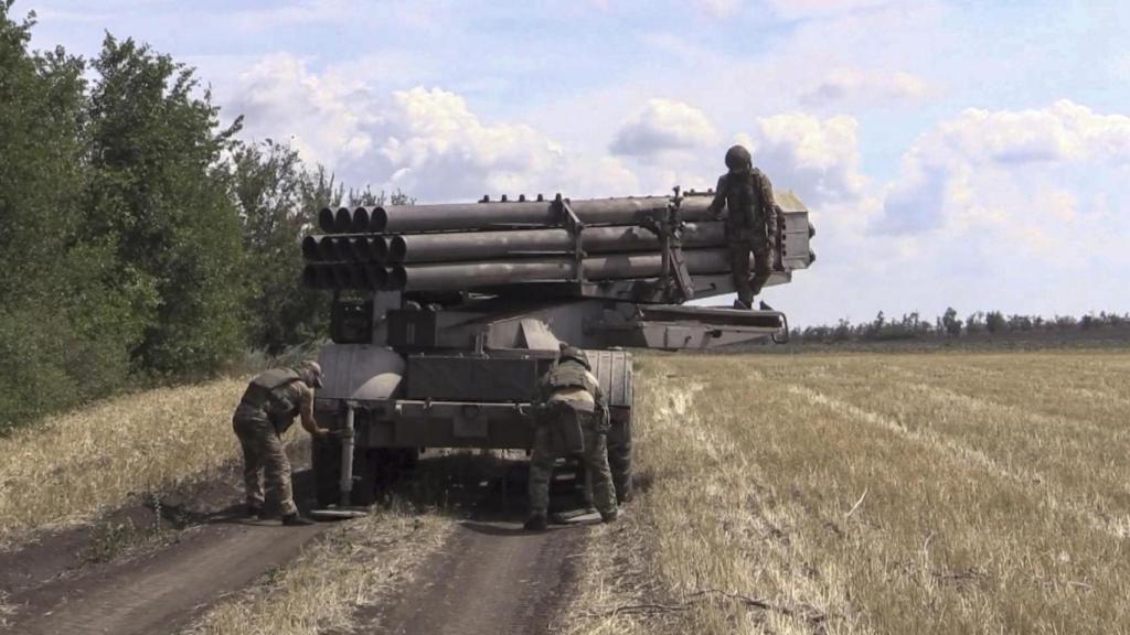 Una imagen distribuida este jueves por el Ministerio de Defensa ruso muestra a un militar ruso preparándose para disparar un lanzacohetes múltiple hacia posiciones ucranianas en un lugar no revelado en territorio ruso.