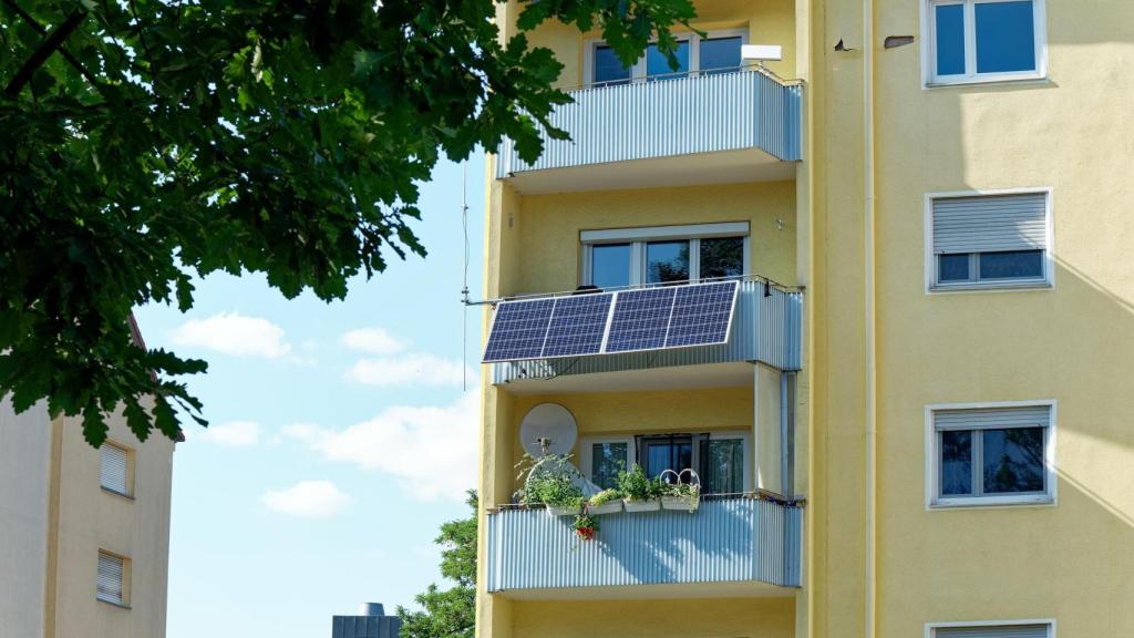 Sistema de placas solares en el balcón de un edificio.