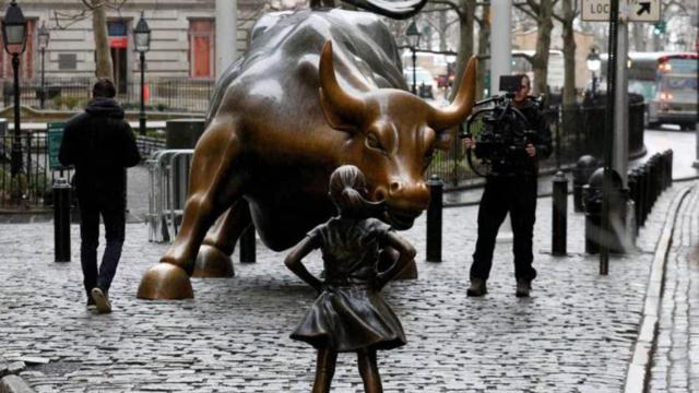 Estatua de La niña sin miedo frente a la estatua del Toro de Wall Street.