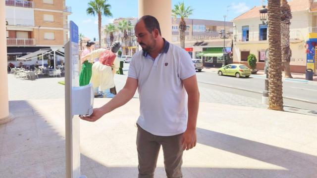 El alcalde de Los Alcázares, Mario Pérez Cervera, junto a uno de los futuros dispensadores de crema solar que se instalarán el próximo año en las zonas comerciales del municipio.