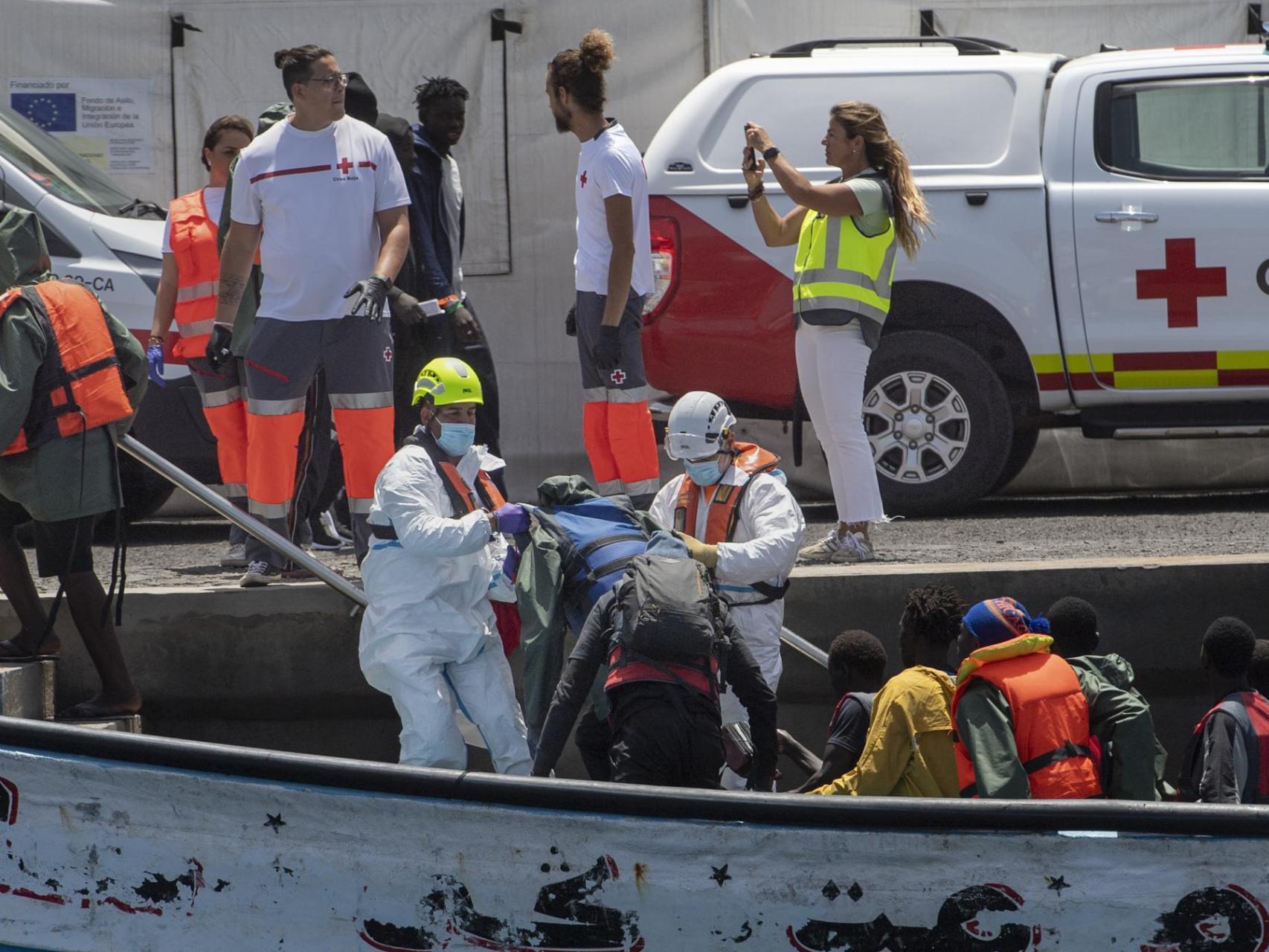 Sanitarios atienden a las personas que viajaban en un cayuco a su llegada al puerto de La Restinga, en El Hierro, el pasado domingo.