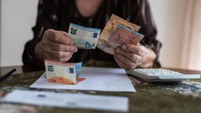 Una mujer de avanzada edad contando dinero.