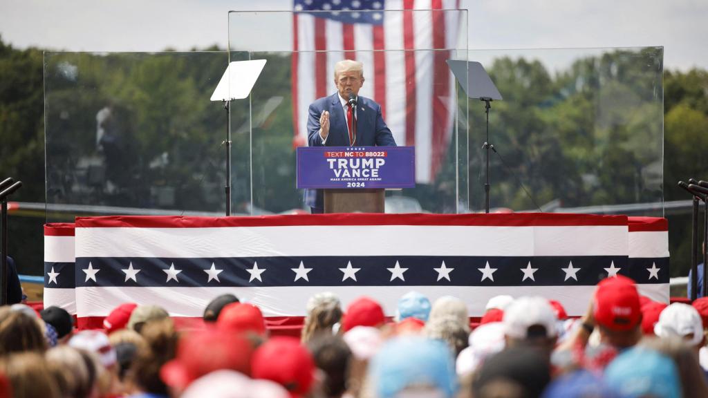 El candidato republicano y expresidente estadounidense Donald Trump habla protegido por un cristal a prueba de balas durante un mitin de campaña en Asheboro.