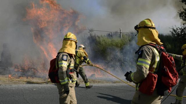 Varios bomberos tratan de apagar el fuego en la parroquia de Oseira en San Cristovo de Cea.