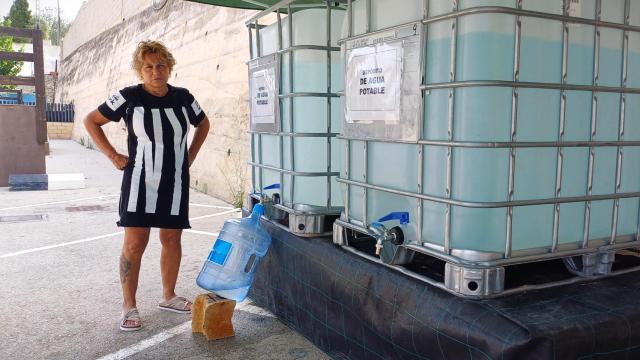 Marina, una de las vecinas de Teulada, rellenando una garrafa de agua en uno de los puntos de reparto.