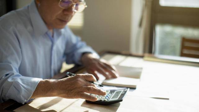 Un hombre mayor calcula cuál será su pensión.