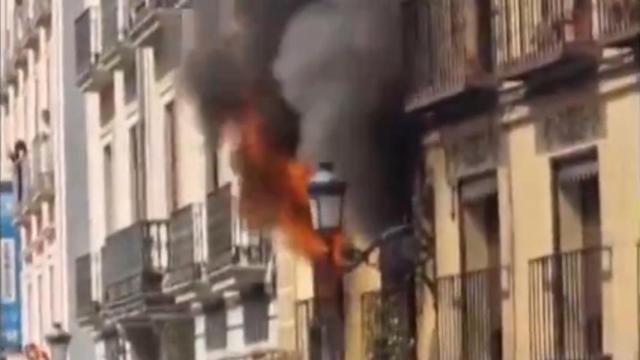 Llamas y columna de humo procedentes del piso incendiado en la calle Mayor este jueves.