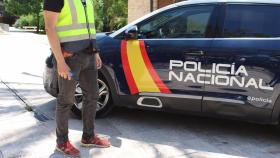 Agente y vehículo de la Policía Nacional.