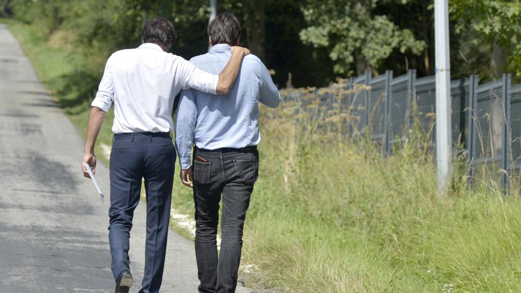 Los dos hermanos, rotos de dolor, abandonando las puertas de la casa de su padre, este sábado.