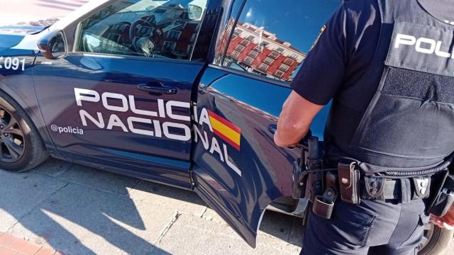 Imagen de archivo de un agente y un coche de la Policía Nacional