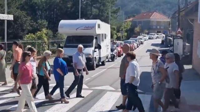 Los vecinos, cruzando un paso de peatones continuamente, esta mañana.