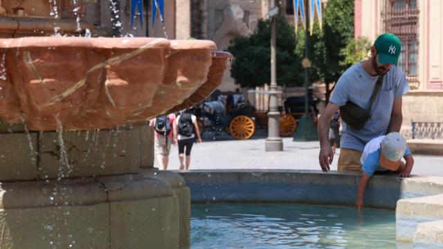 Niño refrescándose en una fuente de Sevilla