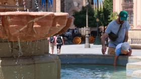 Niño refrescándose en una fuente de Sevilla