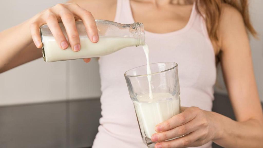 Mujer sirviéndose un vaso de leche.