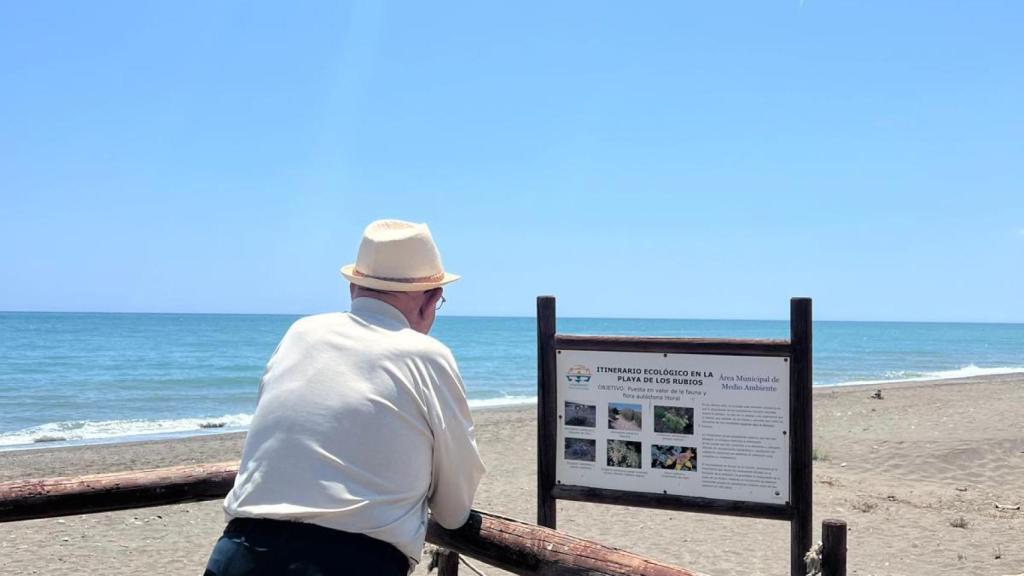 Un anciano en la playa mirando al mar.