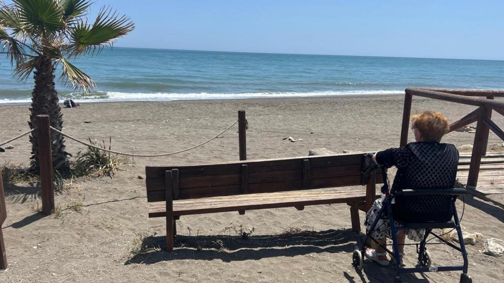 Una señora mirando al mar.