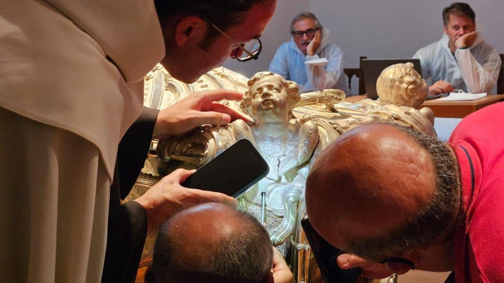 Detalle de los religiosos analizando el sepulcro de Santa Teresa de Jesús.