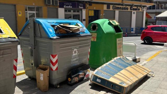 Unos contenedores en El Campello con la basura a su alrededor.