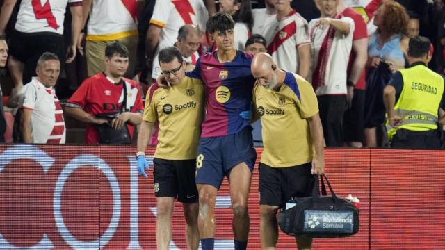 Marc Bernal abandona el estadio de Vallecas acompañado de los médicos.