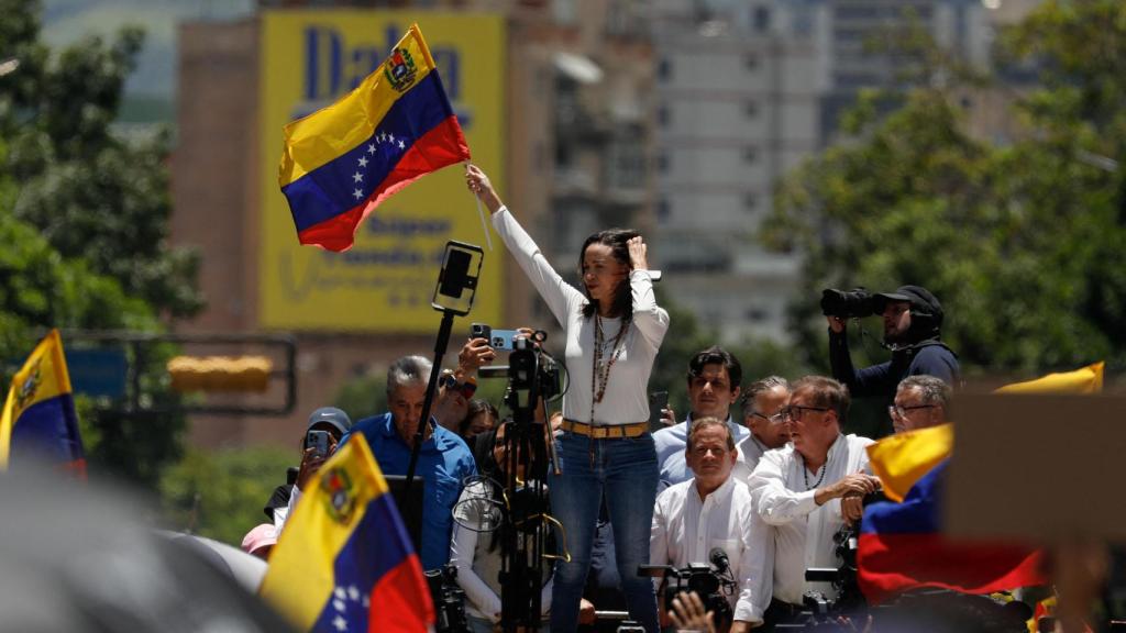 La líder opositora venezolana María Corina Machado ondea una bandera durante una protesta contra los resultados electorales.