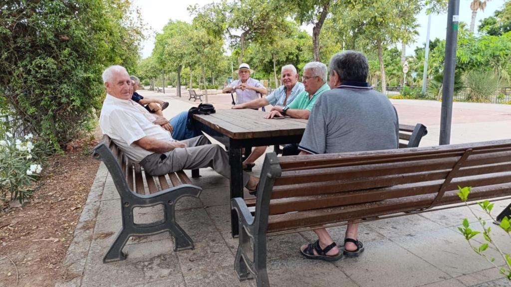 Un grupo de pensionistas charlando en un parque.