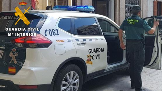 Un agente de la Guardia Civil bajándose de un coche patrulla