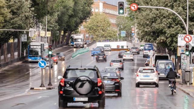 Varios coches circulan bajo la lluvia en Madrid (España).