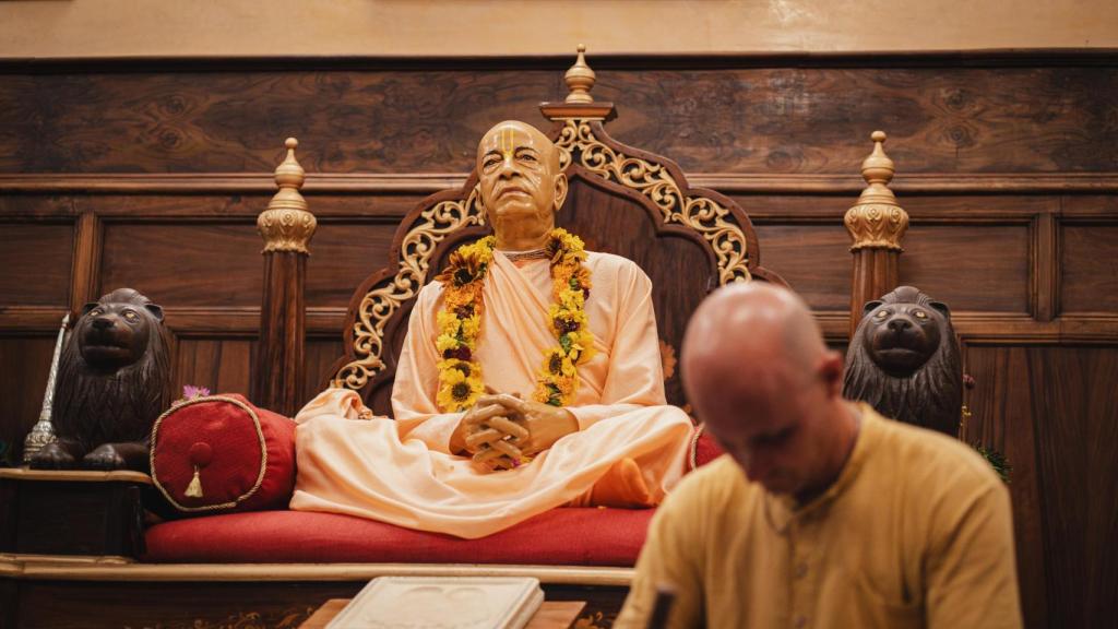 Un hombre medita junto a la estatua de Swami Pradhupada, en el templo de Nueva Vrajamandala.