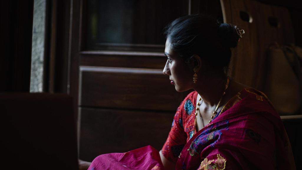 Una de las mujeres de la comunidad mira a través de una ventana del templo.