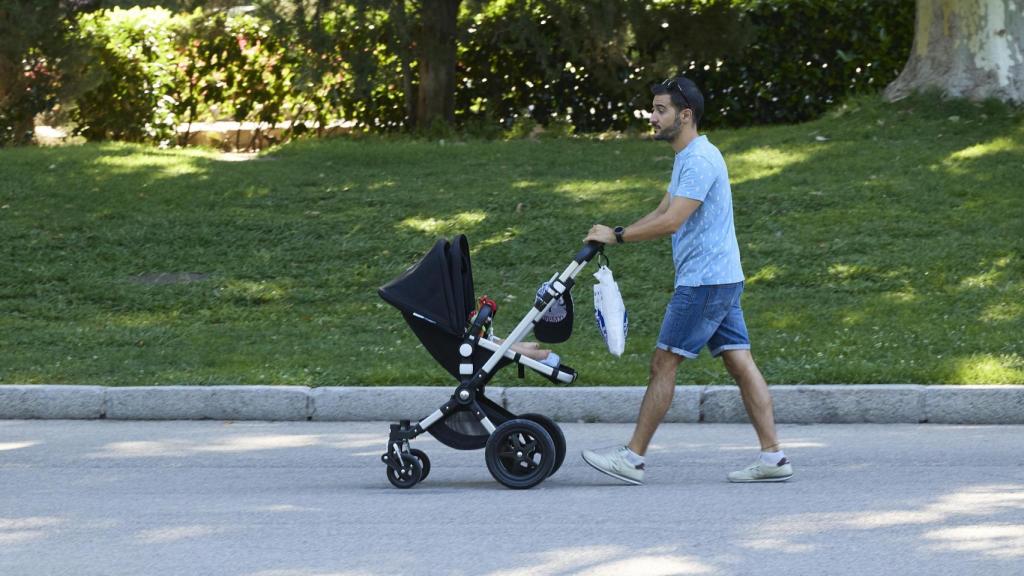 Una persona pasea con un carrito de bebé en el madrileño parque de El Retiro.