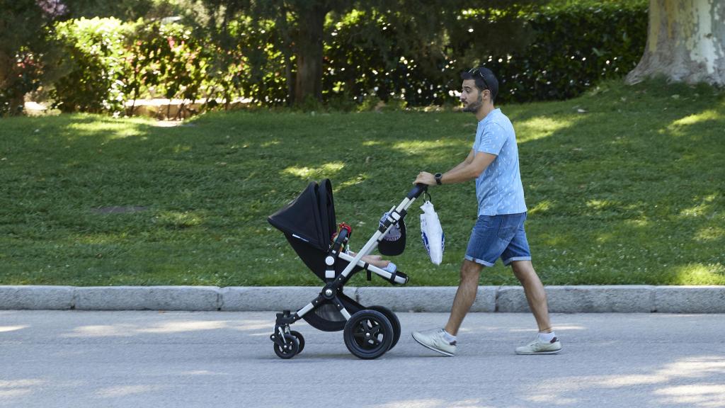 Una persona pasea con un carrito de bebé en el madrileño parque de El Retiro.