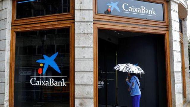 Una persona entrando a la sede de un CaixaBank.