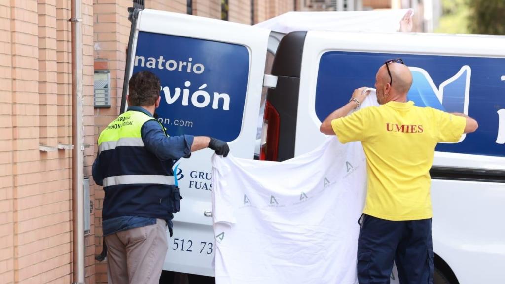 Los servicios funerarios trasladan el cadáver de la víctima del crimen machista de Pino Montano.