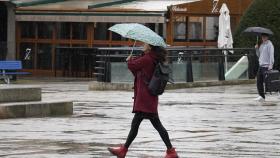 Una mujer se resguarda de la lluvia en El Bierzo