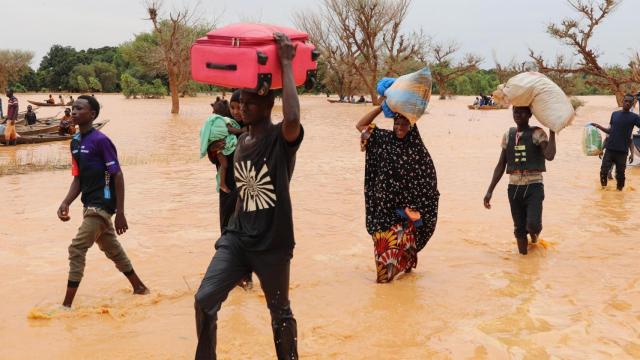 Los residentes caminan por el agua con algunas pertenencias en las inundaciones que azotan Níger.