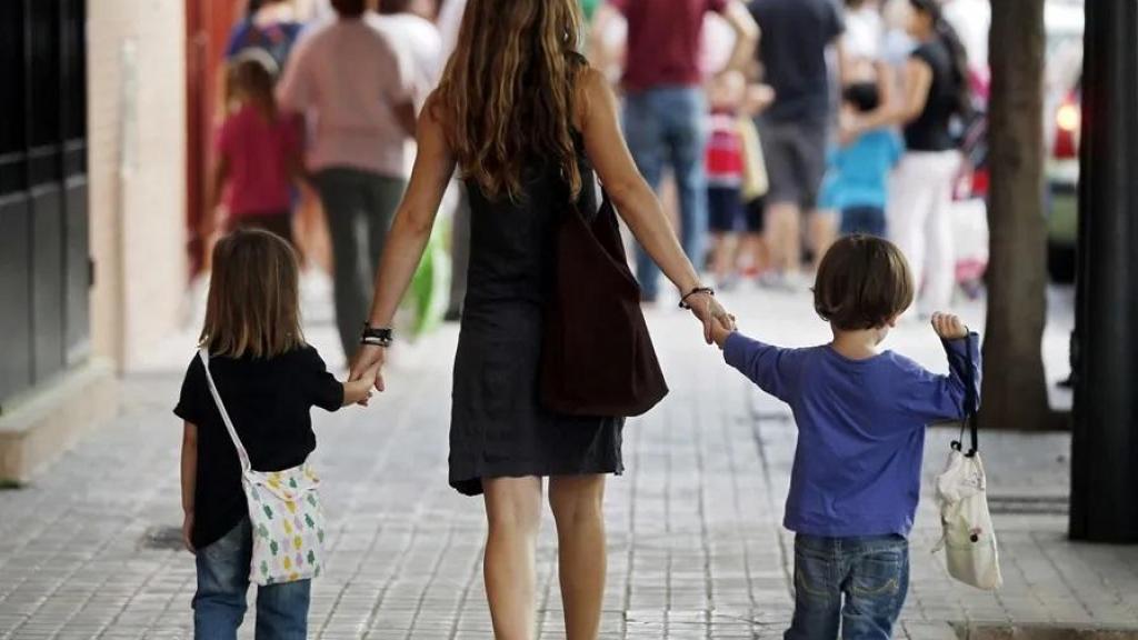 Una madre se dirige con sus hijos al colegio en una imagen de archivo