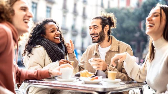 Grupo de personas hablando en la terraza de un bar.