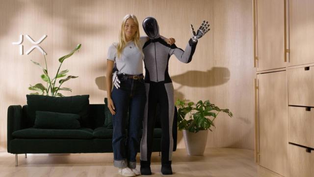 Una persona junto con el robot humanoide Neo Beta.