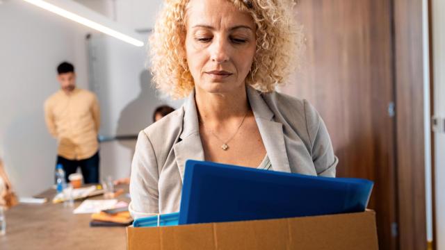 Una mujer recoge sus pertenencias del trabajo, en una imagen de Shutterstock.