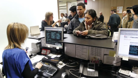 Una funcionaria atendiendo a personas en una oficina.