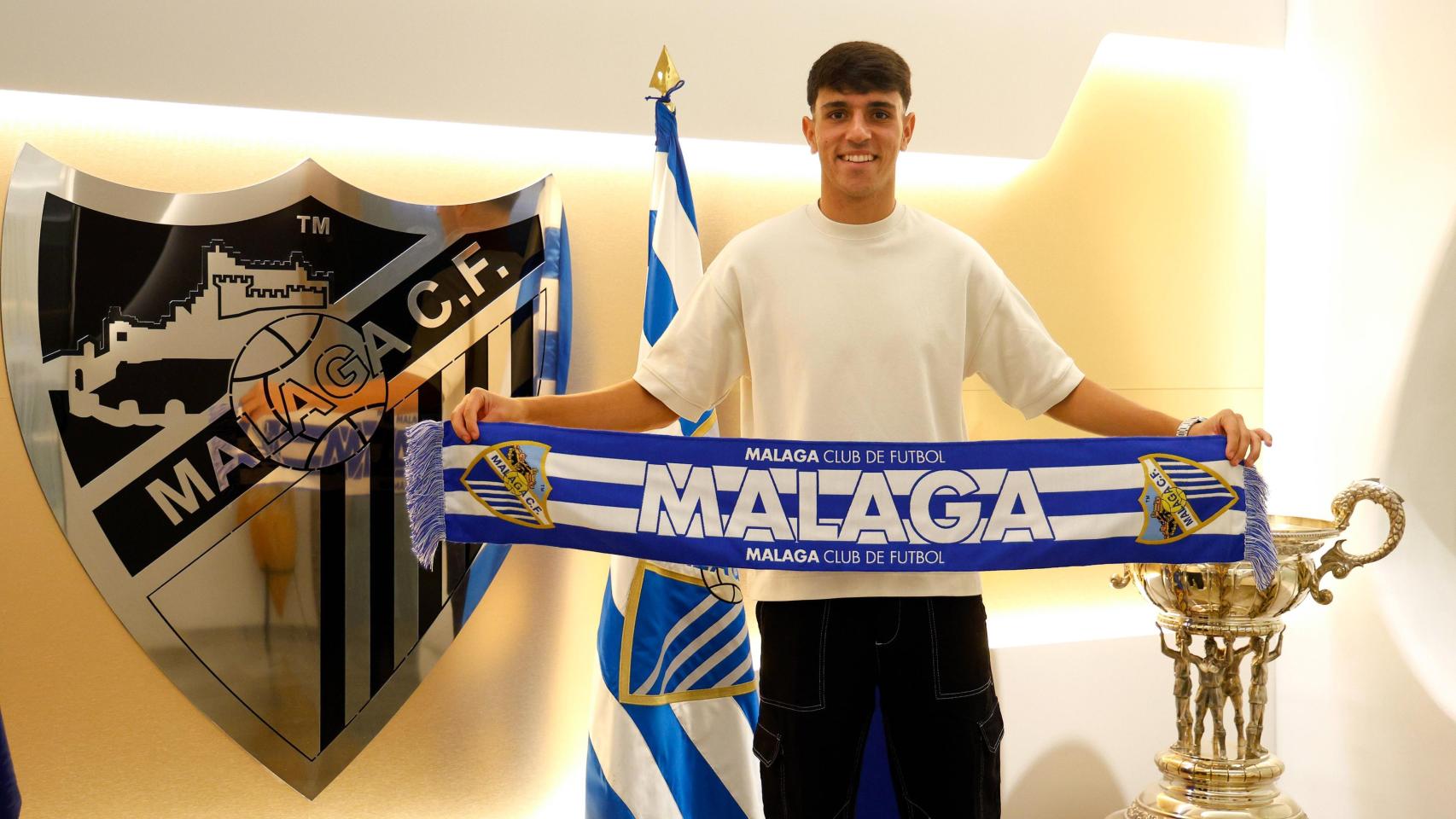 Izan Merino posa con la bufanda del Málaga CF.