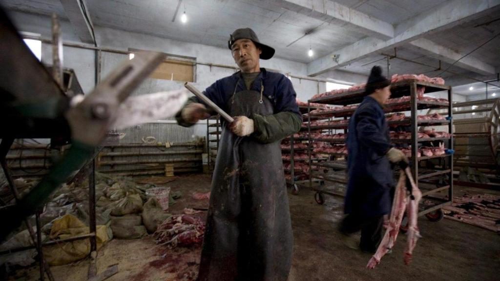 Trabajadores afilan cuchillos antes de quitar la piel a los visones en una granja situada en la ciudad china de Changchun. Imagen de archivo.