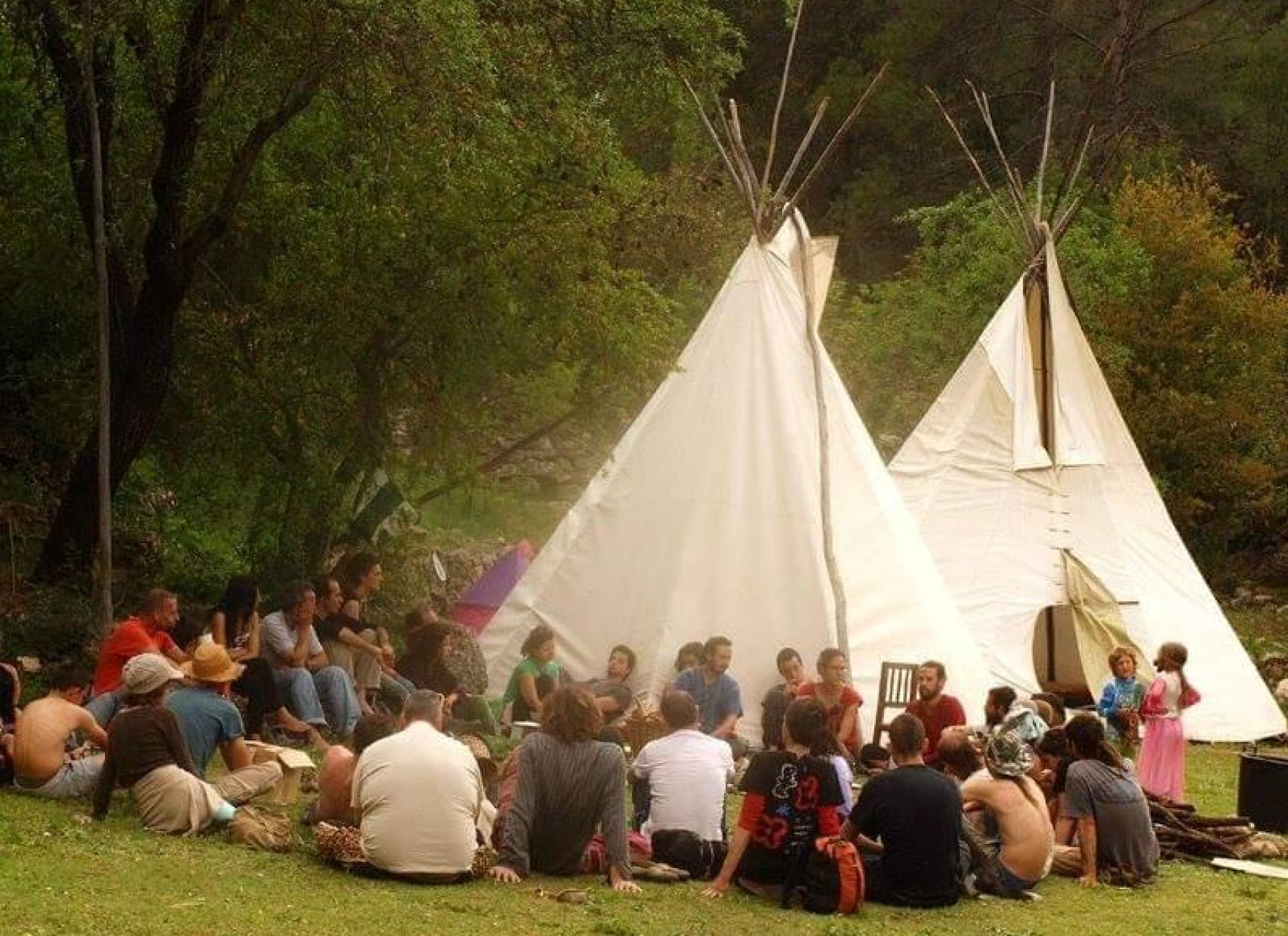 Un grupo de personas frente a unos tipis.