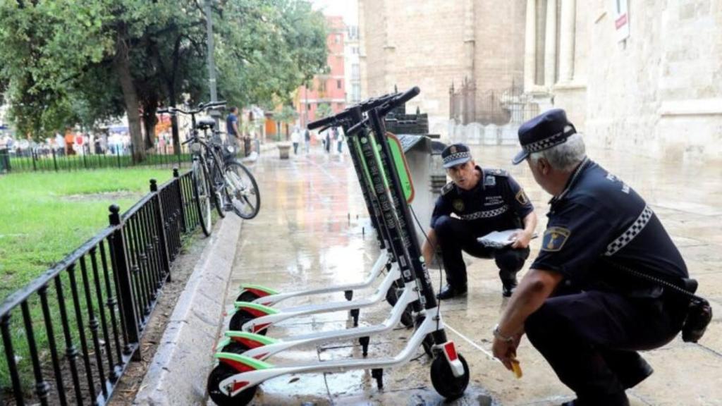 Agentes de la Policía Local trabajan en la retirada de los patinetes eléctricos de alquiler de la empresa Lime en Valencia. Kai Foersterling/EFE