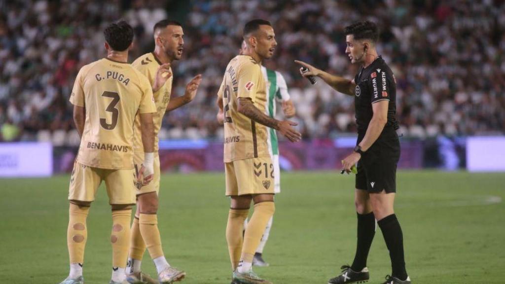 Los jugadores del Málaga CF hablan con el árbitro en el partido contra el Córdoba.