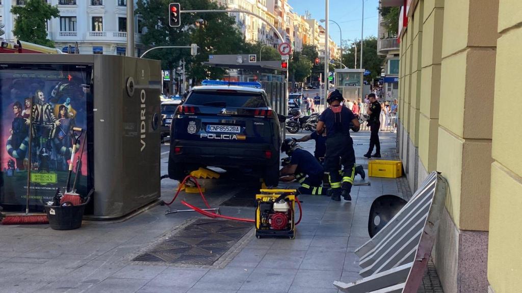 El coche patrulla accidentado, en la acera.