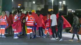 Miembros de la Cruz Roja atienden a inmigrantes de origen subsahariano llegados al puerto de Arrecife, en Lanzarote.