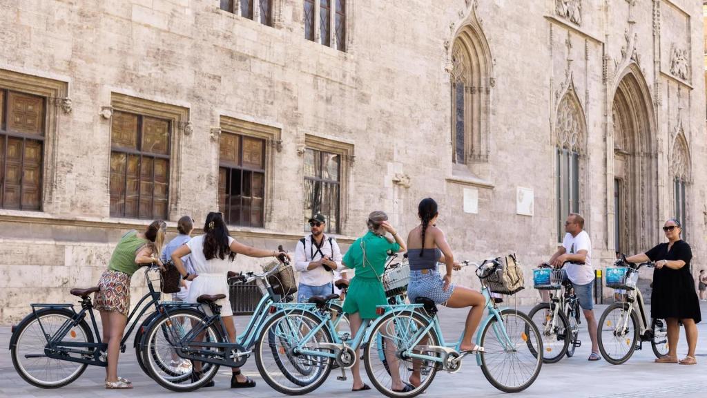 Un grupo de turistas ante el edificio de La Lonja en el centro histórico de Valencia. Efe / Biel Aliño