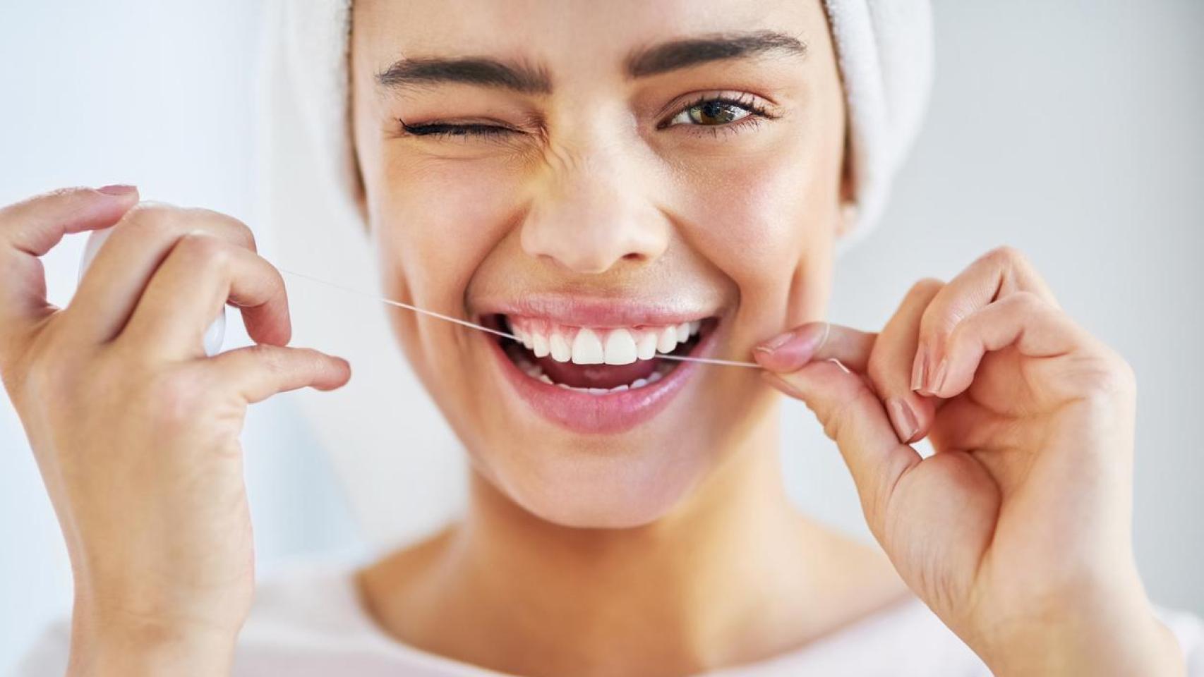 Mujer con hilo dental.
