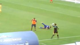Un entrenador salta al campo para derribar al jugador rival.